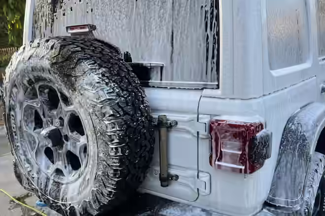 Jeep Wrangler 4xe covered in foam during a hand wash